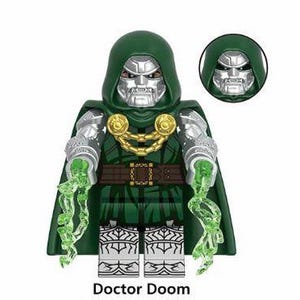 Könnte beinhalten: Eine Doctor Doom-Actionfigur mit grünem Kapuzenmantel, silberner Maske und metallischer Rüstung. Die Figur hat eine goldene Kette und einen Gürtel, mit grünen Energieeffekten, die von den Händen ausgehen. Der Text "Doctor Doom" steht unten.