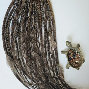 Temporary dreads Afro ponytail with curly synthetic wig strands, combining braids, curls, and dreadlocks. Adorned with feathers, copper charms, beads, and threads, this handmade piece is perfect for bohemian looks and easy hairstyle transformations.
