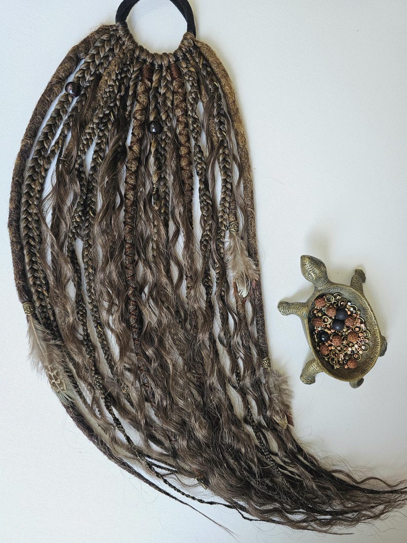 Temporary dreads Afro ponytail with curly synthetic wig strands, combining braids, curls, and dreadlocks. Adorned with feathers, copper charms, beads, and threads, this handmade piece is perfect for bohemian looks and easy hairstyle transformations.
