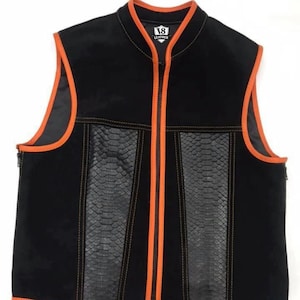 Könnte beinhalten: Schwarze Lederweste mit orangefarbenen Zierleisten und Reißverschluss. Die Weste hat Einsätze aus Kunstschlangenleder und das Logo "18 Leather". Die Weste hat einen Stehkragen und ist ärmellos.