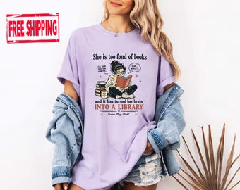 May include: A light purple t-shirt featuring a graphic of a person reading a book with the text: She is too fond of books, I'll read just one chapter, 3 am worth it, and it has turned her brain INTO A LIBRARY, with the signature Louisa May Alcott.
