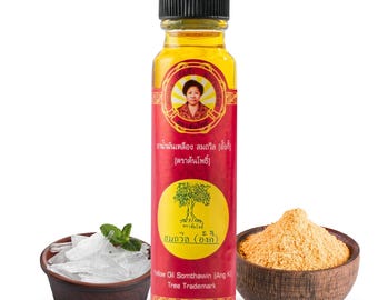 May include: A small bottle of yellow oil with a red label that says "Yelow Oil Somthawin (Ang K) Tree Trademark". The label also features a picture of a woman and a tree. There is a bowl of ice cubes and a bowl of yellow powder in the background.