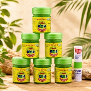 May include: Five small green jars of Hong Thai herbal inhalant stacked in a pyramid, each featuring a yellow label with a green bird logo and Thai text, alongside one white and green Poy-Sian Mark II inhaler tube standing upright on the right.