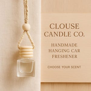May include: A clear, square glass car air freshener with a wooden cap and a natural rope hanger. The text "CLOUSE CANDLE CO." and "HANDMADE HANGING CAR FRESHENER" are visible on a wooden sign. The phrase "CHOOSE YOUR SCENT" is also displayed.