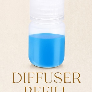 Puede incluir: Una botella de plástico transparente con tapa blanca, llena de líquido azul brillante. Las palabras "DIFFUSER REFILL" están impresas en marrón debajo. El fondo es una tela beige claro.