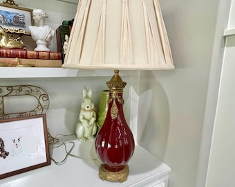 Lámpara antigua de porcelana roja "sangre de buey" con monturas de latón. 75 cm de alto.