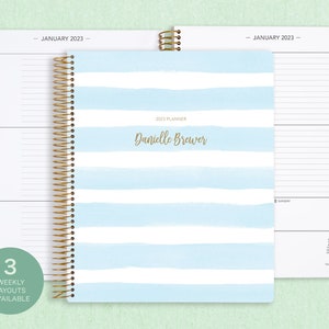 8.5x11" Posy Paper Co. 2023/2024 weekly planner with the blue watercolor stripes cover design showcasing horizontal layout in the background.
