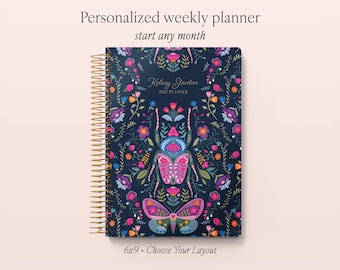 May include: A personalized weekly planner with a dark blue cover featuring a colorful beetle and butterfly illustration, gold spiral binding, and the text "Kelsey Stanton 2027 PLANNER". The cover also displays "Personalized weekly planner", "start any month", and "6x9 • Choose Your Layout".