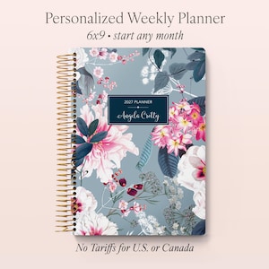 May include: A personalized weekly planner with a floral design. The cover features pink and white flowers with green leaves on a blue background. The planner is 6x9 inches and has a gold spiral binding. The text on the cover reads "2027 Planner" and "Angela Cretty."
