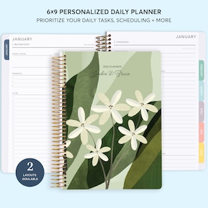 May include: A 6x9 personalized daily planner with a floral design featuring white flowers on a green background. The planner has a gold spiral binding and includes the text "2025 Planner Jackie B Bruce".