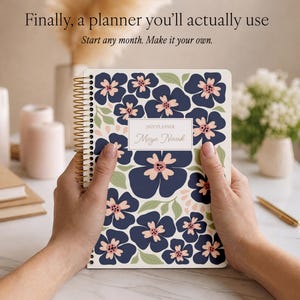 May include: A spiral-bound 2027 planner with a dark blue floral pattern on a white background. The cover features a central rectangular label with the text 2027 PLANNER and Maya Novak. The planner has gold-toned wire binding along the left side.