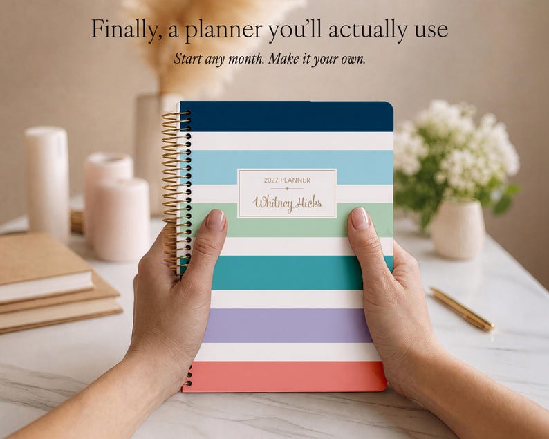 Puede incluir: Una agenda 2027 de espiral con rayas horizontales en azul marino, azul claro, verde, cerceta, lavanda, blanco y coral. La portada incluye una etiqueta rectangular blanca con el texto 2027 PLANNER y Whitney Hicks.