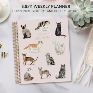 May include: An 8.5x11 inch weekly planner with a spiral binding and a cover featuring watercolor illustrations of various cat breeds. The planner includes horizontal, vertical, and hourly layouts. The text "2019 Planner Julia Bishop" is also visible.