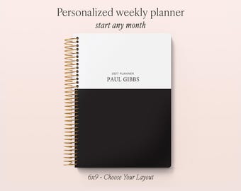 May include: A weekly planner with a gold spiral binding, featuring a two-tone cover design with a white top half and a black bottom half. The text reads 2027 PLANNER PAUL GIBBS. The planner is labeled as 6x9 inches, personalized, and start any month.