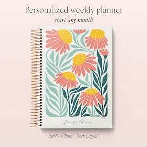 May include: A personalised weekly planner with a gold spiral binding, featuring a white cover with a floral pattern of pink flowers with yellow centres and green leaves. The text reads Personalised weekly planner, start any month, Jennifer Burns, 2027, 6x9, Choose Your Layout.