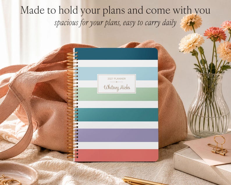 Puede incluir: Una agenda 2027 con encuadernaci&oacute;n en espiral dorada que presenta rayas horizontales en azul oscuro, azul claro, verde, blanco, verde azulado, morado y coral. La portada muestra el texto 2027 PLANNER y el nombre Whitney Hicks en un rect&aacute;ngulo blanco.