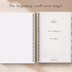 May include: Open white wedding planner with gold spiral binding. The planner includes sections for planning, timeline, and vendors. The text "The beginning you'll never forget" is at the top.
