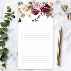 May include: A floral notepad with a pink and burgundy floral design and the word "notes" at the top. The notepad has lined paper and is perfect for writing down ideas, to-do lists, or reminders.
