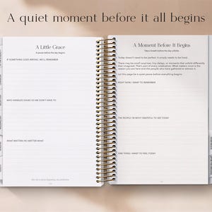 May include: Open planner with gold spiral binding, featuring lined pages and section tabs. Text on the left page reads "A Little Grace" and on the right page "A Moment Before It Begins". The top text says "A quiet moment before it all begins".