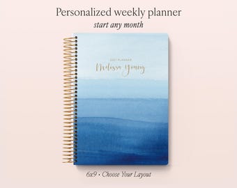 May include: A weekly planner with a gold spiral binding and a blue watercolor gradient cover. The cover features the text 2027 PLANNER and the name Melissa Young in gold script. The planner measures 6x9 inches and includes a customizable layout.