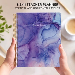 May include: An 8.5x11 inch teacher planner with a gold spiral binding. The cover features an abstract watercolour design in shades of purple and blue, with the text "2024 Planner" and "Andrea Davis".
