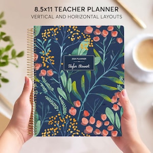May include: A blue teacher planner with a floral pattern featuring pink and yellow flowers. The planner is 8.5x11 inches and has a gold coil binding. The cover says "2024 Planner" and "Taylor Stewart".