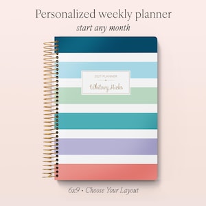 May include: A personalised weekly planner with a gold spiral binding, featuring horizontal stripes in dark blue, light blue, white, green, teal, lavender, and coral. A central white label displays the text 2027 PLANNER and Whitney Hicks.