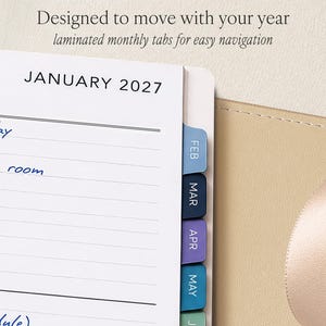 Puede incluir: Una p&aacute;gina de agenda que muestra enero de 2027 con espacio de escritura rayado y notas manuscritas en azul. La p&aacute;gina presenta pesta&ntilde;as mensuales laminadas de colores etiquetadas como FEB, MAR, APR, MAY y JUN. El texto superior dice: Designed to move with your year.