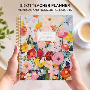 May include: A 8.5x11 inch teacher planner with a floral design. The cover features a colorful bouquet of pink, red, yellow, and orange flowers on a light blue background. The planner is titled "2023 Planner" and "Julie Bishop".