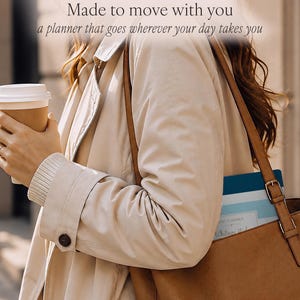 Puede incluir: Una agenda de rayas azules y blancas con una etiqueta rectangular que muestra el texto "Whitney M" metida en un bolso de cuero marr&oacute;n. La agenda tiene rayas horizontales en varios tonos de azul y blanco, y el texto "Made to move with you" es visible arriba.
