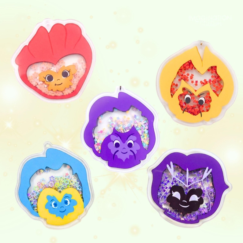 Five colorful acrylic pansy-shaped keychains with smiling faces and glitter, arranged in a semi-circle on a light background.