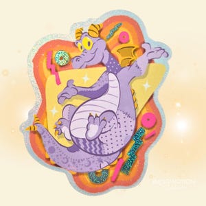 May include: A whimsical sticker featuring a purple dragon with yellow eyes and horns, set against a rainbow-colored background. The dragon has a stitched design and is surrounded by glittery accents and shapes. The text "IMAGINATION STATION" is visible.