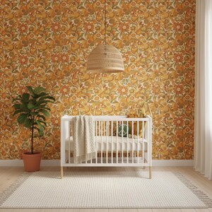 May include: A white wooden crib with a cream-colored knit blanket draped over the side, positioned in front of a wall covered in orange, yellow, and green floral wallpaper featuring peace signs, with a woven pendant light hanging above.