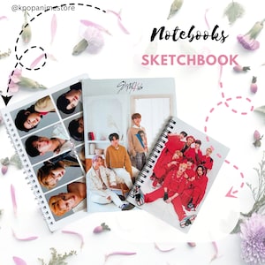 May include: Three notebooks featuring a K-pop boy band. The notebooks are all spiral bound and have different designs. One notebook has a group photo of the band in red outfits, another has a photo of the band members in casual clothing, and the third notebook has a collage of individual photos of the band members.