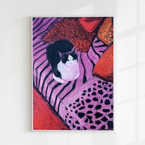 May include: A framed artwork featuring a black and white cat curled up on a pink and purple striped surface, surrounded by red and orange pillows. The artwork is a colorful, abstract illustration.
