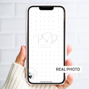 May include: A smartphone in a pink case, held in a hand. The screen displays a white background with a dotted pattern and the text "PSD MOCK UP CREATIONS". The words "REAL PHOTO" are also visible.