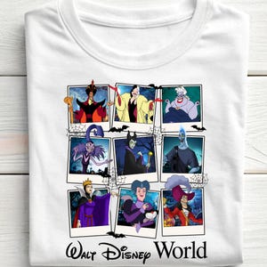K&ouml;nnte beinhalten: Wei&szlig;es T-Shirt mit einer Collage von Disney-B&ouml;sewichten in Polaroid-Rahmen. Die Bilder zeigen Charaktere wie Dschafar, Cruella de Vil und Ursula, mit Spinnweben und Flederm&auml;usen. Der Text "Walt Disney World" ist unten aufgedruckt.