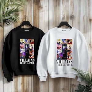 May include: Two sweatshirts, one black and one white, with a graphic print of Disney villains. The graphic features Maleficent, Ursula, Cruella de Vil, and other villains. The text on the sweatshirts reads "Villains The Evil Tour".