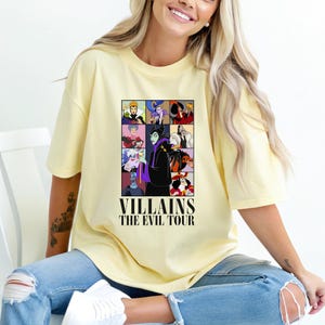 May include: A yellow t-shirt with a graphic of Disney villains. The graphic features Maleficent, Ursula, Cruella de Vil, and other villains. The text "VILLAINS THE EVIL TOUR" is printed below the graphic.