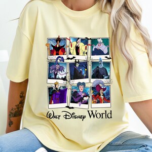K&ouml;nnte beinhalten: Hellgelbes T-Shirt mit einer Collage von Disney-B&ouml;sewichten in Polaroid-Rahmen. Der Text "Walt Disney World" ist unten in Schwarz aufgedruckt. Das T-Shirt besteht aus einem weichen Material.