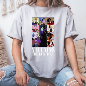 May include: A gray t-shirt with a graphic of Disney villains. The graphic features Maleficent, Ursula, Cruella de Vil, and other villains. The text "VILLAINS THE EVIL TOUR" is printed below the graphic.