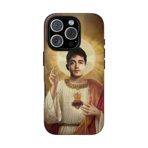 May include: A phone case with a portrait of a man in religious clothing, with a halo and a glowing heart. The case has a brown border and a camera cutout.