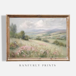 May include: A framed landscape painting depicts a serene meadow filled with wildflowers in shades of pink and white. Rolling hills and a cloudy sky create a soft, pastoral scene. The artwork is signed "RANFURLY PRINTS".