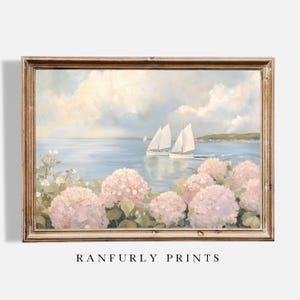 May include: A framed landscape painting depicting sailboats on a blue sea beneath a cloudy sky. Pink hydrangea flowers are in the foreground. The text "RANFURLY PRINTS" is at the bottom.