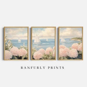 May include: A triptych of framed art prints depicting a coastal scene. Each print shows sailboats on the sea, pink hydrangeas, and a light blue sky. The frames are light wood. The text "RANFURLY PRINTS" is at the bottom.
