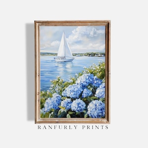 May include: A framed painting depicting a sailboat on a blue sea, with blue hydrangeas in the foreground. The sky is a light blue with fluffy white clouds. The painting is in a wooden frame. The text "RANFURLY PRINTS" is at the bottom.