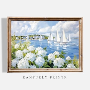 May include: A framed painting depicts a serene coastal scene. White sailboats glide on blue water under a cloudy sky. Lush white hydrangeas bloom in the foreground. The text "RANFURLY PRINTS" is at the bottom.