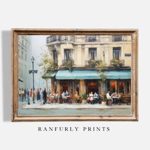 Könnte beinhalten: Ein gerahmter Druck einer Pariser Cafészene. Das Kunstwerk zeigt ein Gebäude mit einer blauen Markise, Sitzgelegenheiten im Freien und Menschen. Der Druck hat eine warme, Vintage-Ästhetik, mit dem Text "RANFURLY PRINTS" unten.