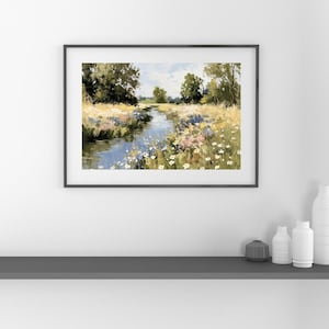 以下が含まれることがあります： 額縁に入った風景画は、野生の花が咲き乱れる野原を縫うように流れる穏やかな川を描いています。 このアートワークは、青、緑、黄、ピンクの色使いで、部分的に曇った空の下、川岸に沿って木々が並んでいます。
