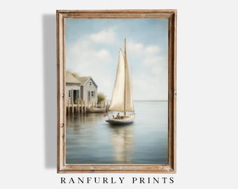 May include: A framed print of a sailboat on the water near a small building. The sailboat has a white sail and is in the center of the image. The building is on the left side of the image. The sky is blue with some clouds. The text "RANFURLY PRINTS" is at the bottom.